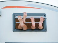 caravans lange mensen benen uit raam