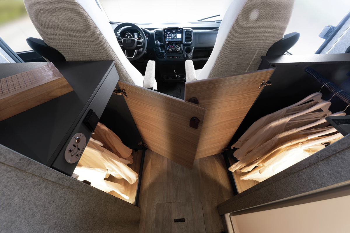 Kastruimte met kledingstangen achter de cabinestoelen in de Dethleffs Trend I 7027