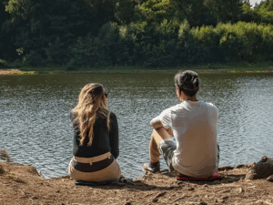 Wandelaars zitten comfortabel op hun outdoor zitkussens aan het water