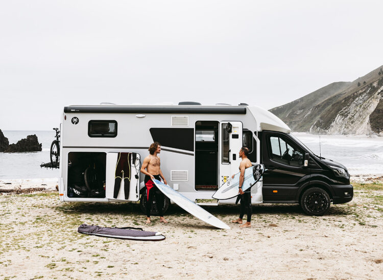 Halfintegraalcamper Sunlight UNLTD 2027 op het strand met twee surfers