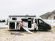 Halfintegraalcamper Sunlight UNLTD 2027 op het strand met twee surfers