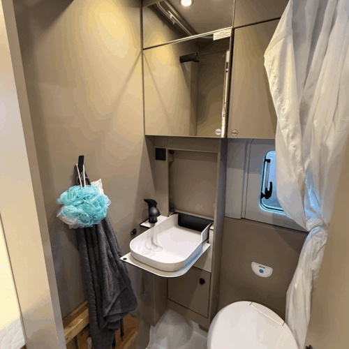 Badkamer met douche, toilet en opklapbare wastafel in de Carado CV595 X-Edition