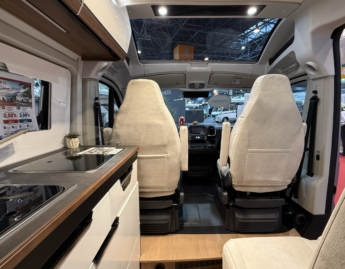 Interieur van de Rapido V64 met links het keukenblok, rechts de dinettebank en voor de cabinestoelen