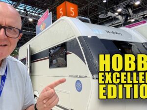 Videostill van het interieur van de Hobby Excellent Edition 495UL met houtdesign en sfeerverlichting, getoond in een YouTube-video van Campingtrend