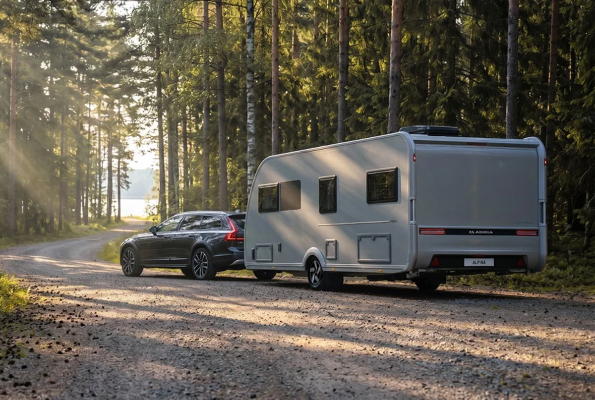 Adria Alpina 583 UL op een weg in het bos met een auto ervoor