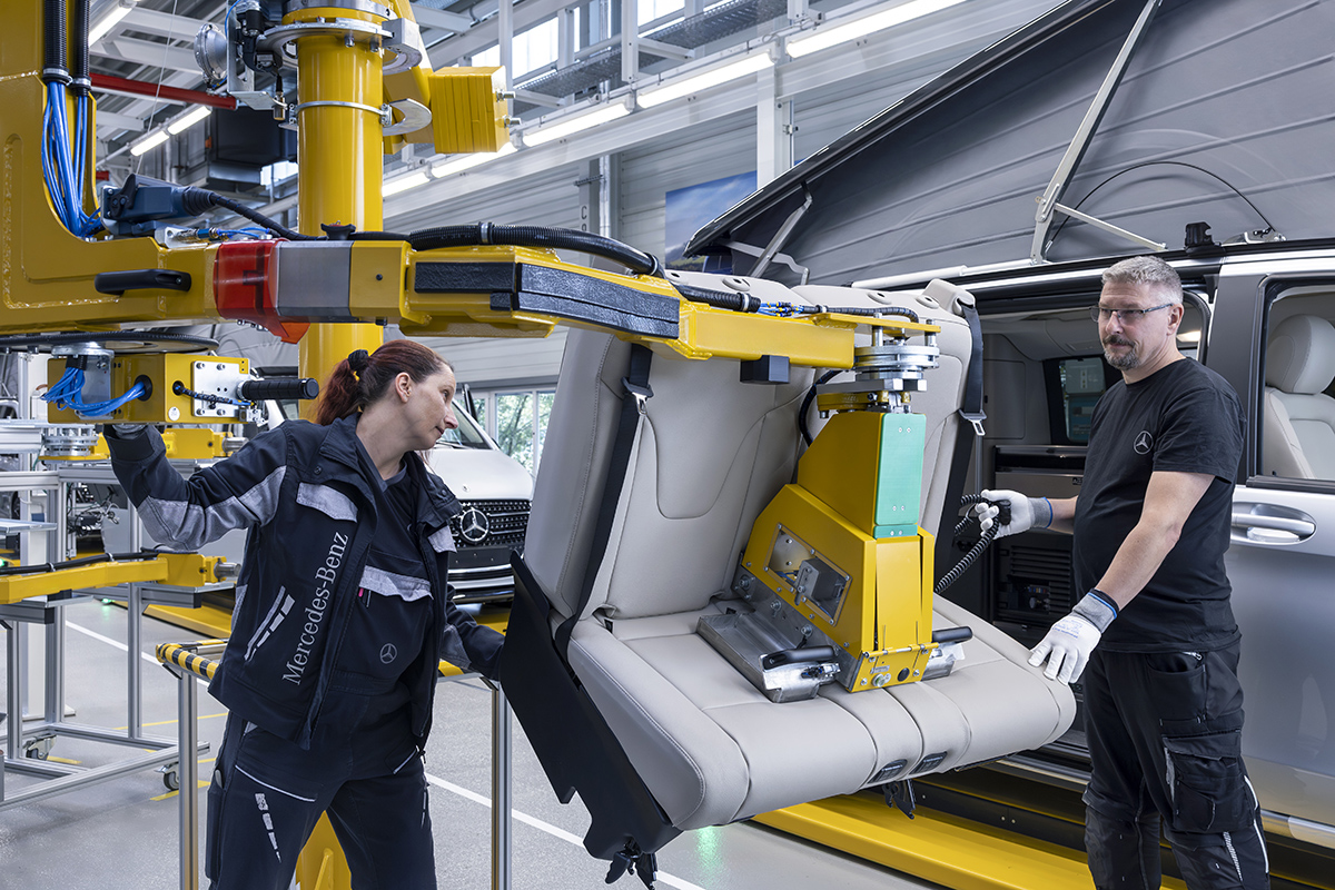 Medewerkers van de Mercedes-Benz fabriek in Ludwigsfelde plaatsen een bank in de Marco Polo.