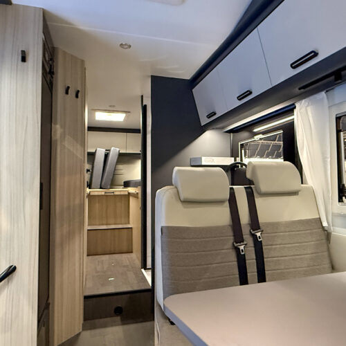 Doorkijkje in de alkoofcamper Sun Living A75 SL 20E met rechts de zitgroep en achterin de enkele bedden.