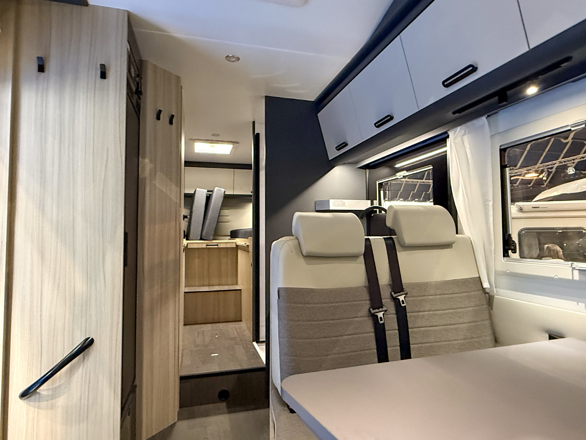 Doorkijkje in de alkoofcamper Sun Living A75 SL 20E met rechts de zitgroep en achterin de enkele bedden.